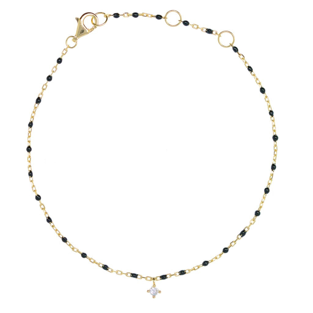 Delicate gold-plated bracelet with black enamel beads and a small hanging cubic zirconia charm.