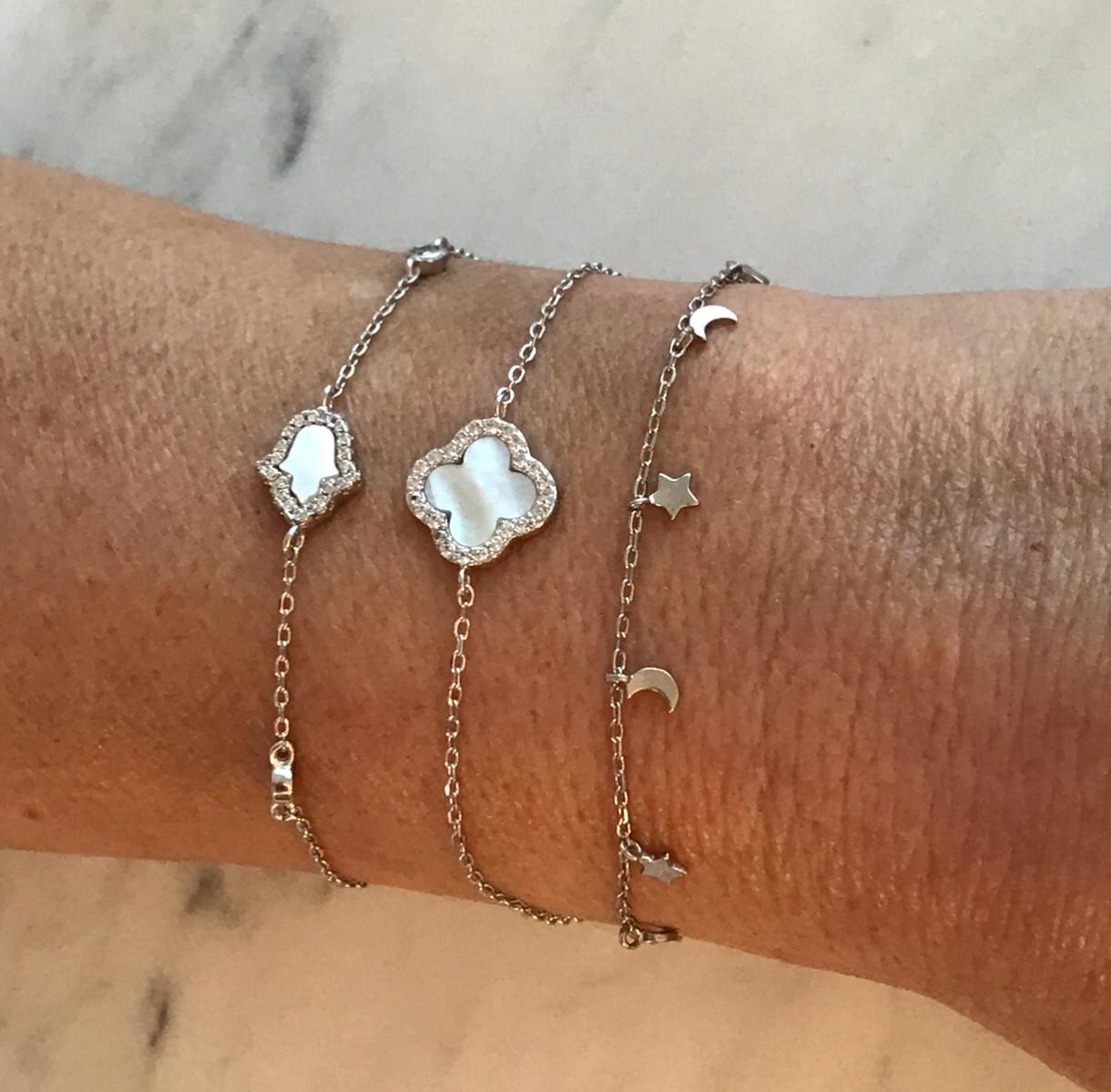 Sterling silver chain bracelet with mother of pearl Hamsa and cubic zirconia accents.