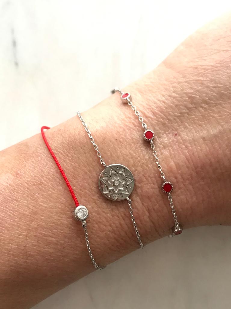
Sterling silver chain bracelet with an embossed disk displayed  

